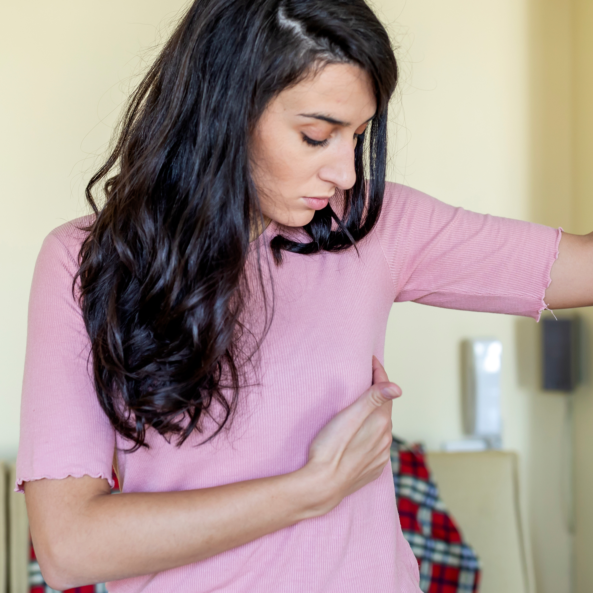 女人的手臂碰到下面的乳房因为不适。
