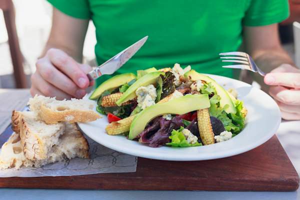 健康的午餐 - 人吃沙拉与鳄梨