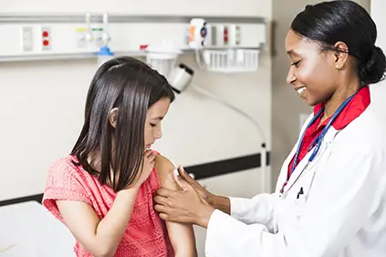 医生用绷带包扎儿童疫苗注射部位。