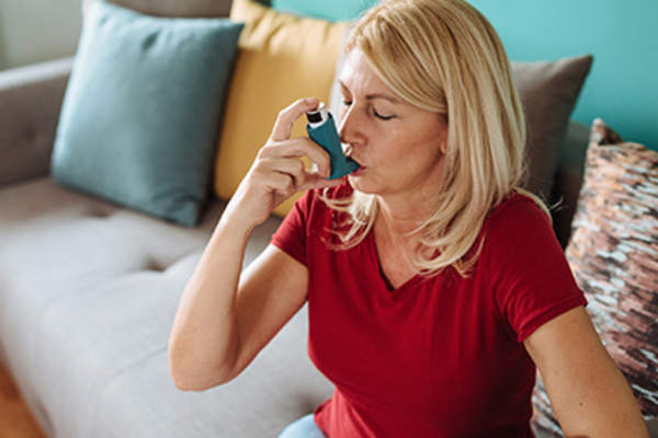 有哮喘的女人在用吸入器。