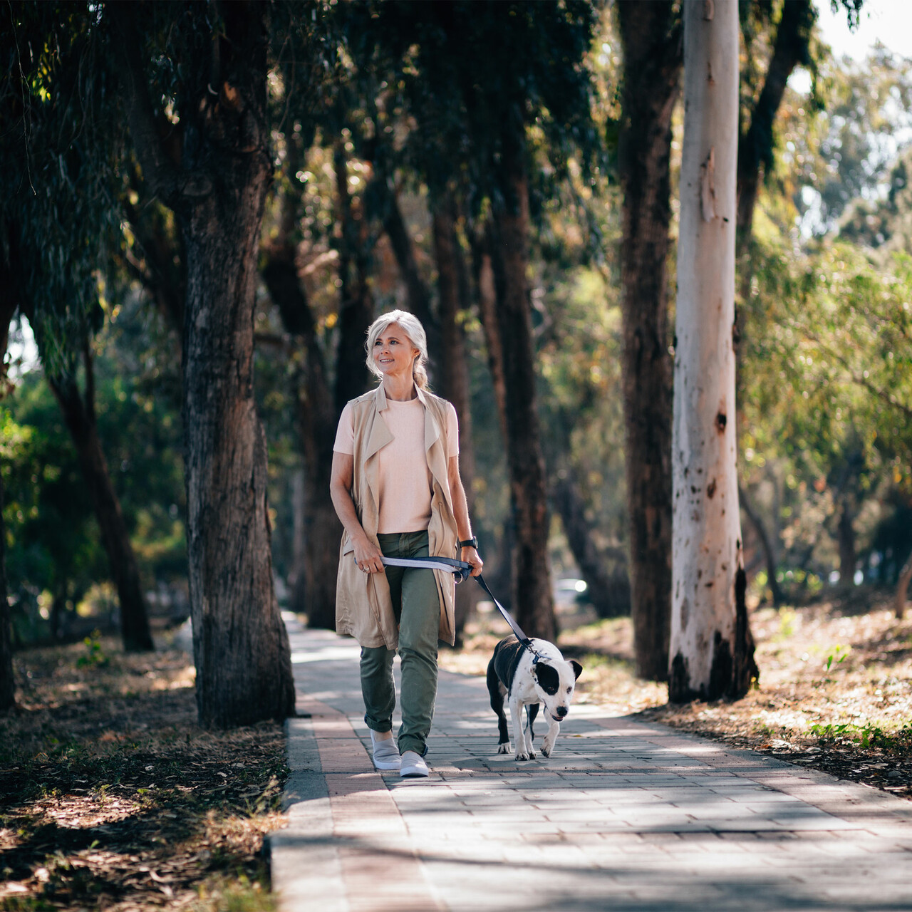 一位老媪牵着她的狗在外面