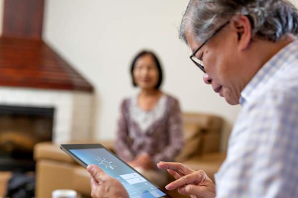 一位资深人士正在用家庭安全技术研究ipad