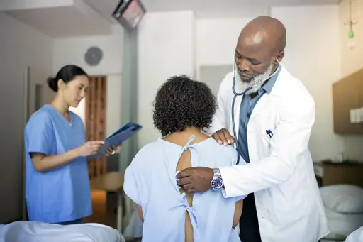 Doctor checking patient's breathing with a stethoscope