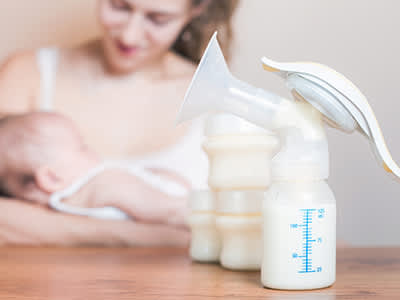 母亲和婴儿用手动吸奶器和奶瓶。
