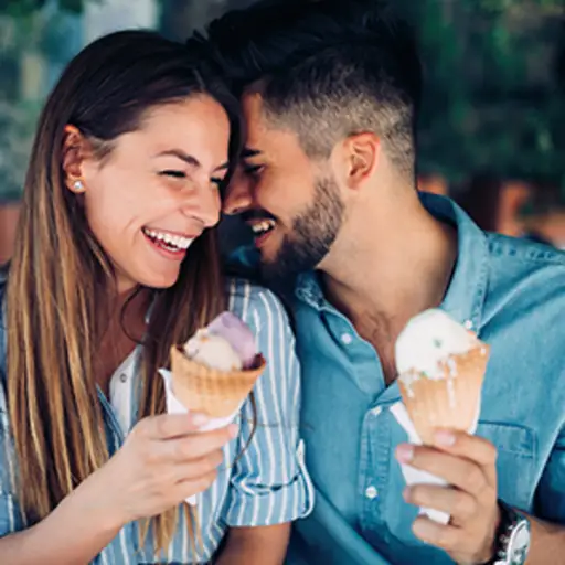 笑着的情侣在吃冰淇淋。