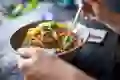 A woman eats a chickpea salad at a table