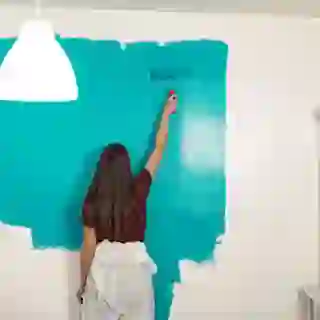 Woman DIY painting wall