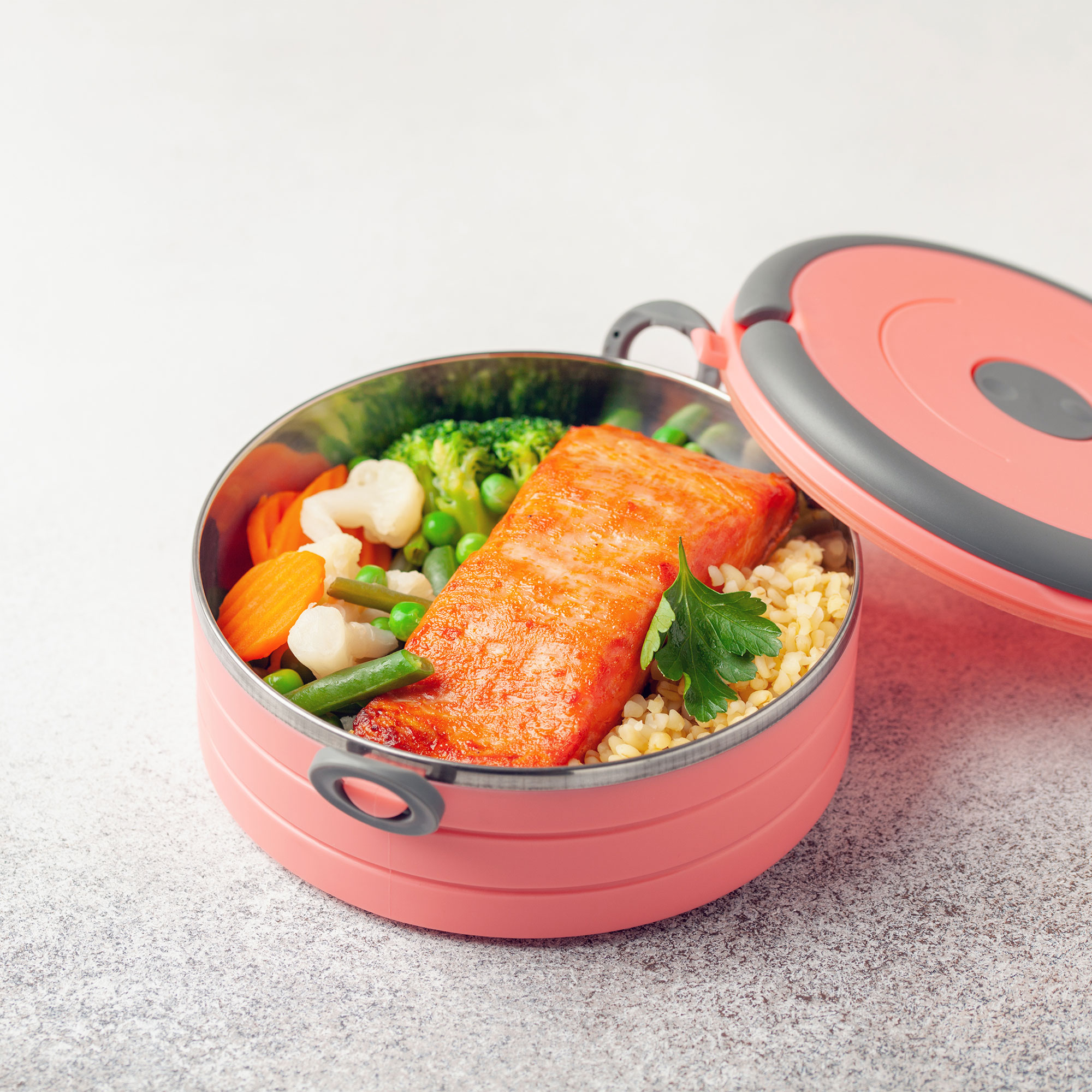 一个装满鲑鱼和蔬菜的食物容器