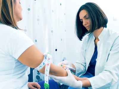 护士抽血检查患者是否符合临床试验条件。
