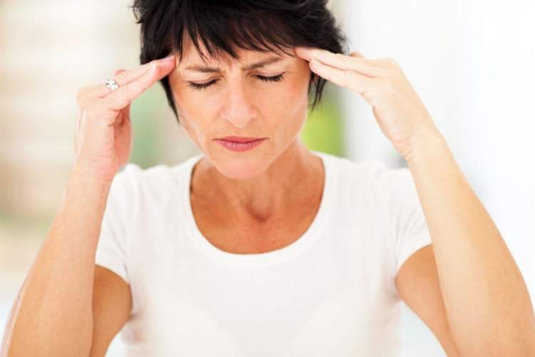 一个女人抱着头坐在床边