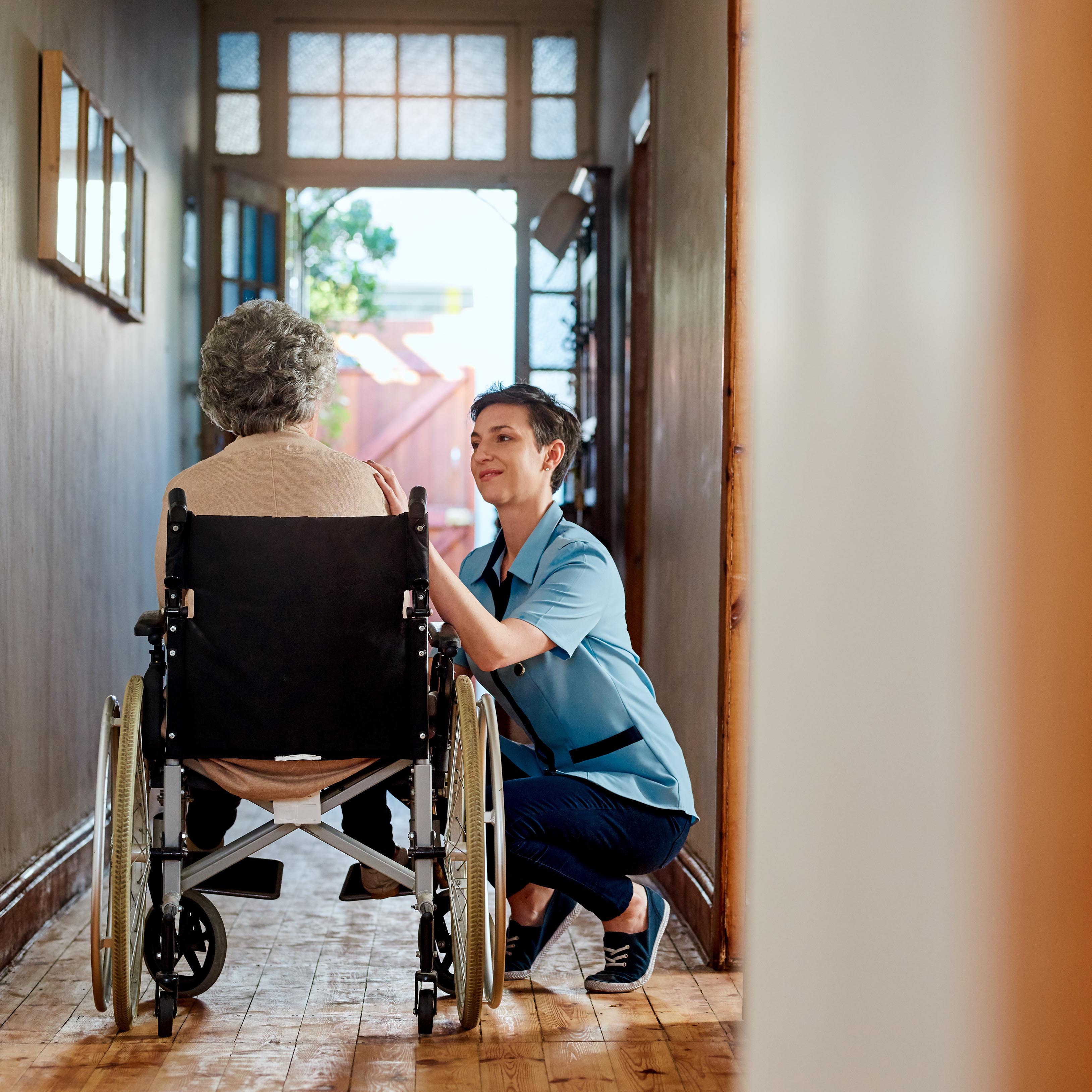 照顾者帮助高级坐在轮椅上的女人