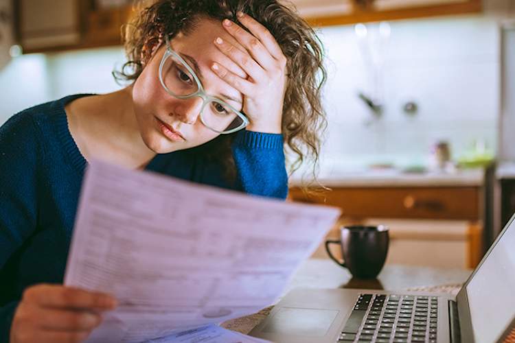 Woman worried about health care costs with medical insurance form.