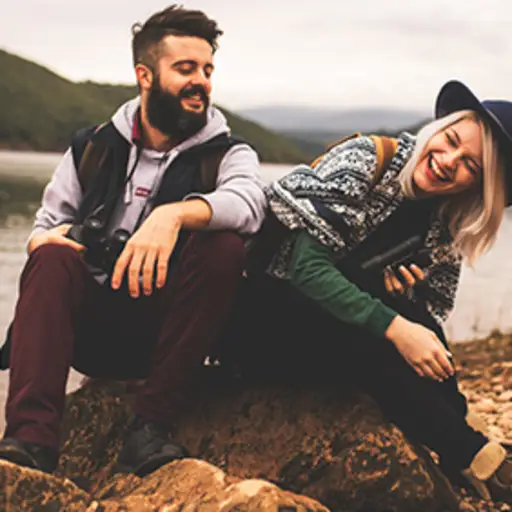 笑的夫妇,当休息在山附近的一张徒步旅行时。