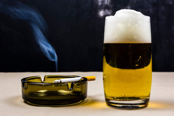 烟灰缸里的香烟就在啤酒旁边。
