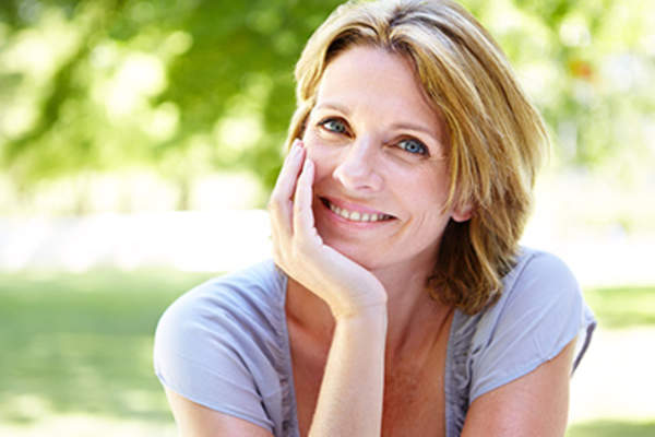 中年妇女在外面微笑。