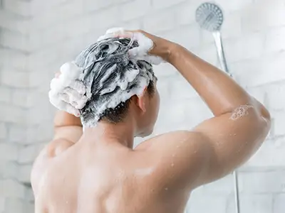 男人用洗发水洗头。