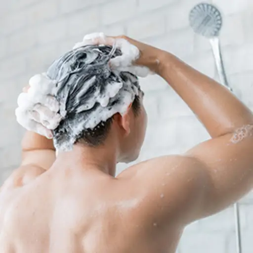 男人用洗发水洗头。