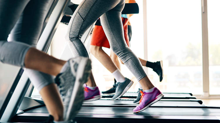 女性在健身房的跑步机上跑步。