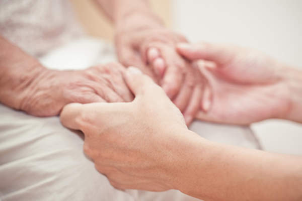 保姆抱着痴呆病人的手形象。