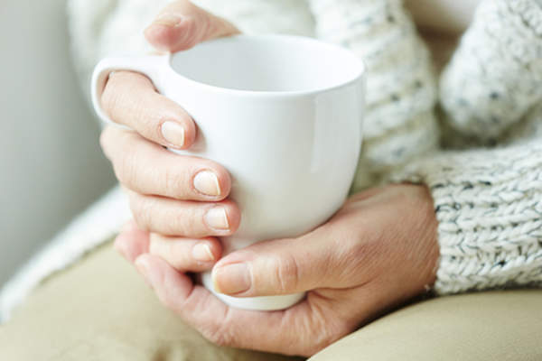 年长的成年女子抱着茶像一杯茶。