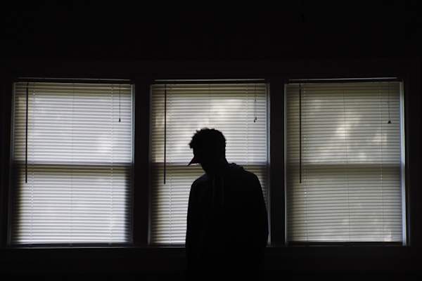 男人站在黑暗的房间里向下看,侧影