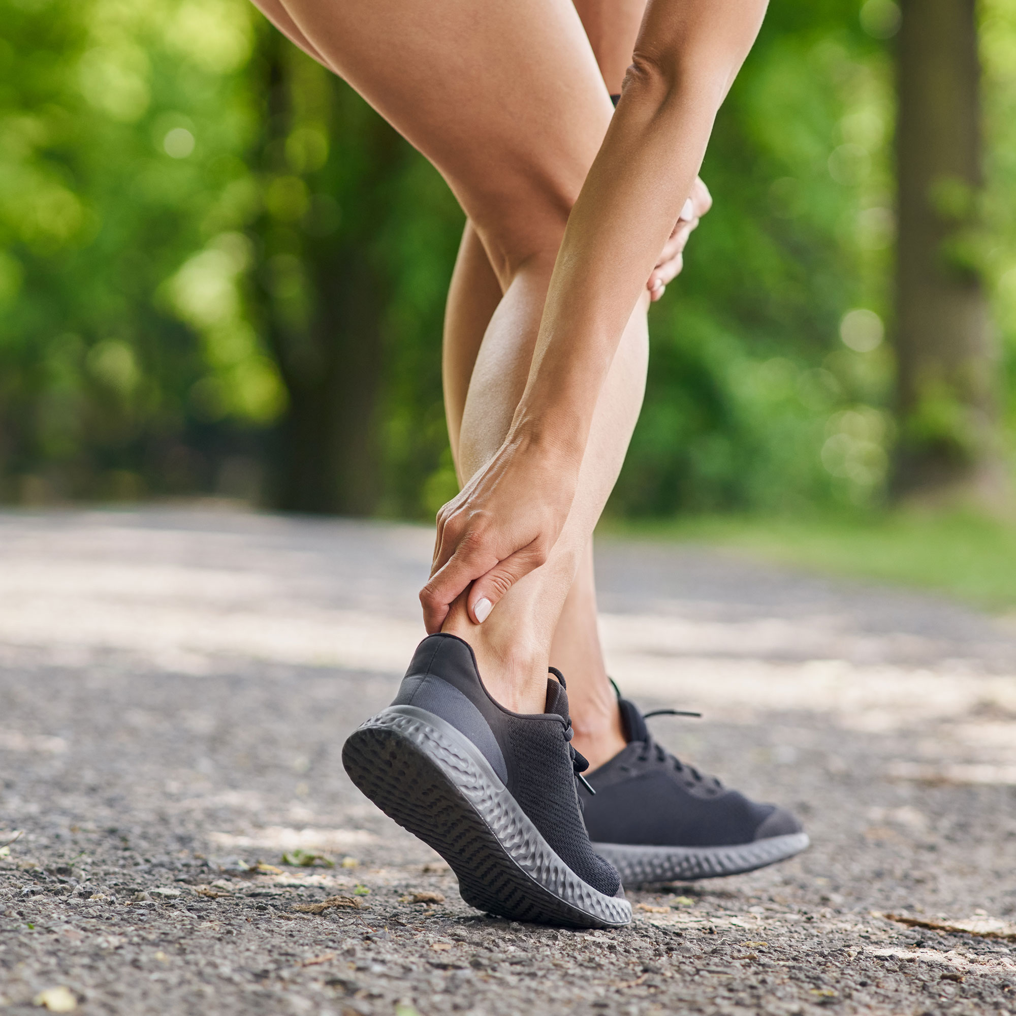 一个女人触摸脚踝的后背