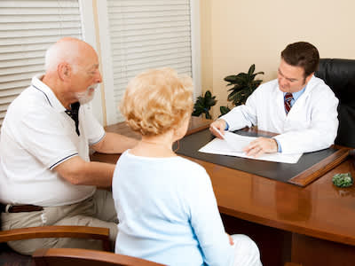 医生查看健康档案与老夫妇。