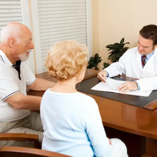 医生与年长的夫妇一起审查健康记录。