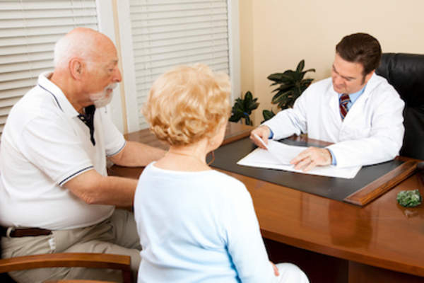 医生查看健康档案与老夫妇。