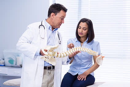 病人指出她在脊椎解剖模型上感到疼痛的地方。