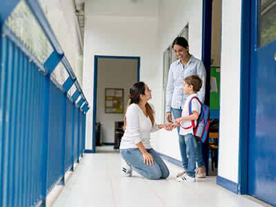 母亲去学校接儿子，并和老师谈话。