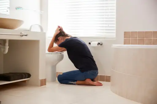 Woman vomiting into toilet