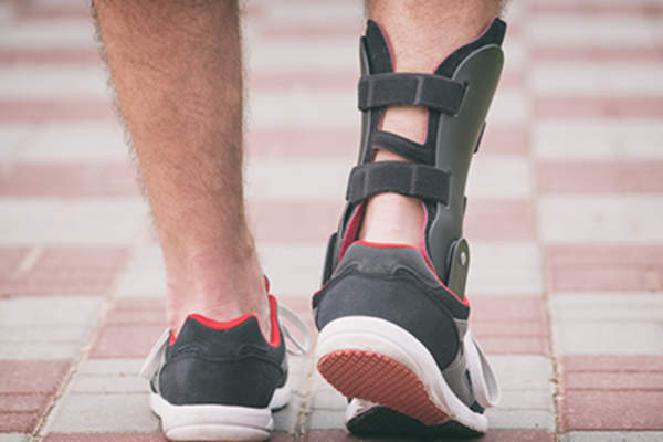 带着脚踝支架四处走动的男人。