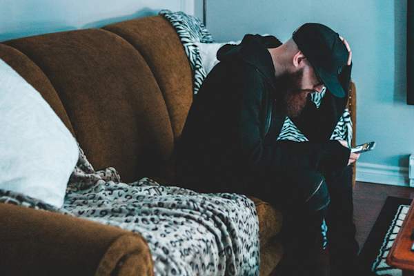 男子坐在沙发上,百无聊赖