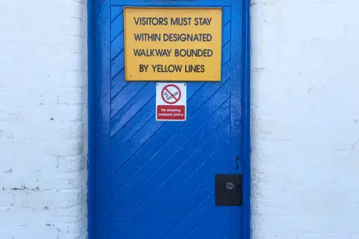 蓝色的门上写着“游客必须呆在用黄线隔开的指定走道内”