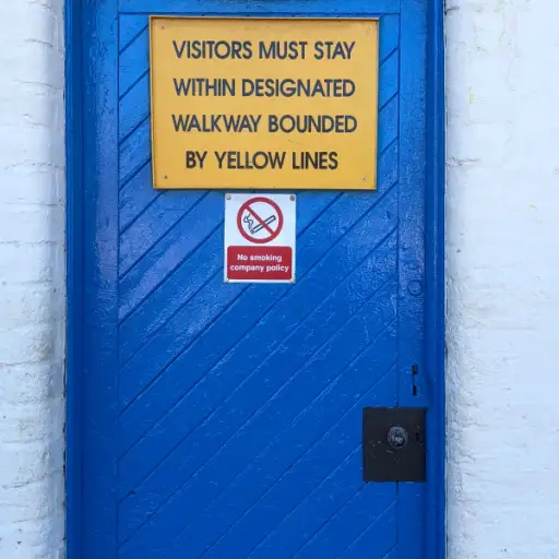 蓝色的门上写着“游客必须呆在用黄线隔开的指定走道内”