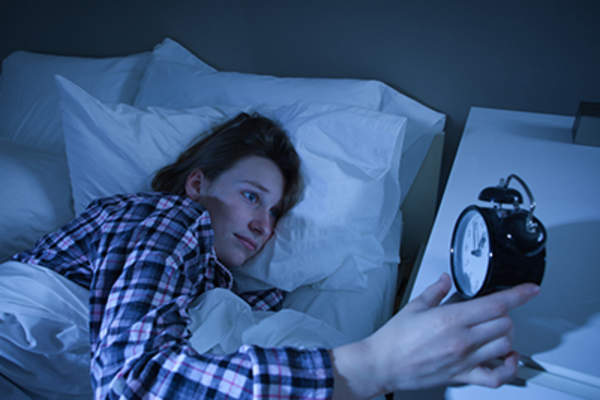 女人失眠看着闹钟。