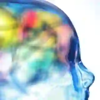 Glass figure of head with various colors coming from the areas of the figure that would be the brain