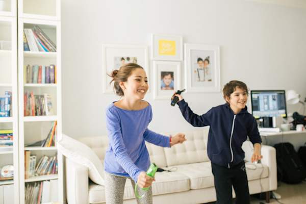 孩子们拿着电子游戏控制器跳舞