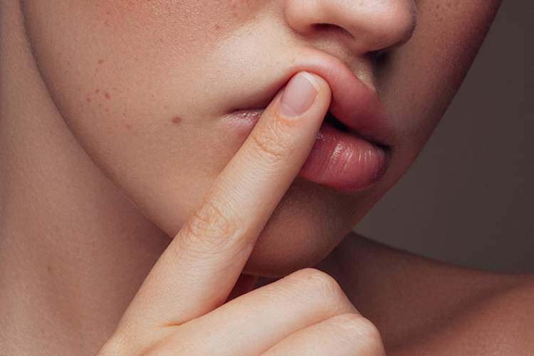 年轻女人与她的手指放在唇边。
