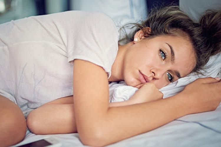 躺在床上的年轻女子忧心忡忡。