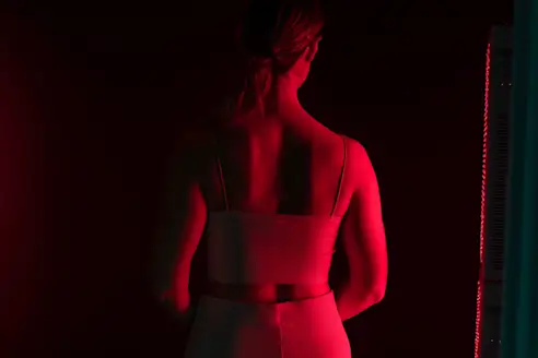 A woman receives red light therapy on her back