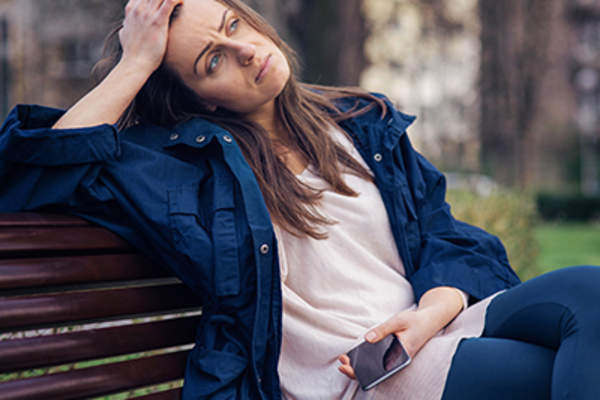 郁闷的女子坐在长椅上。