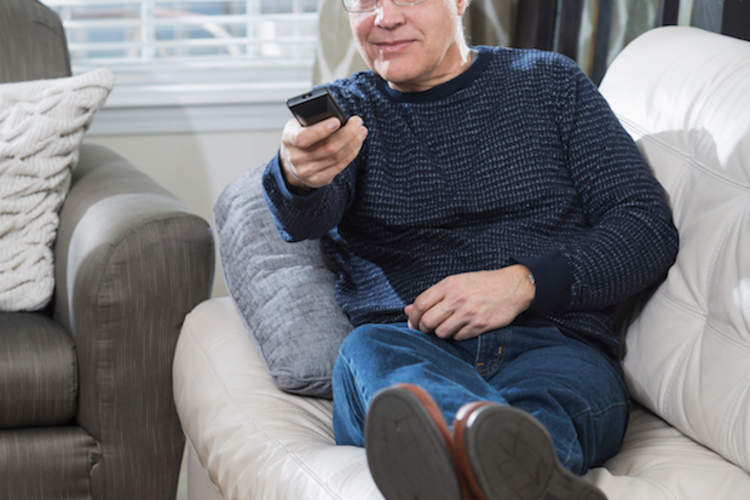 成熟的男人看电视在客厅