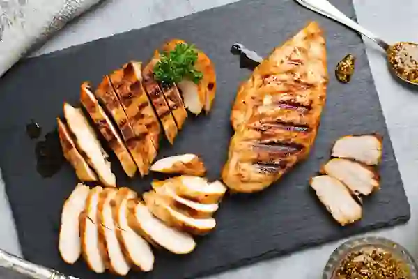 Grilled chicken on a cutting board.