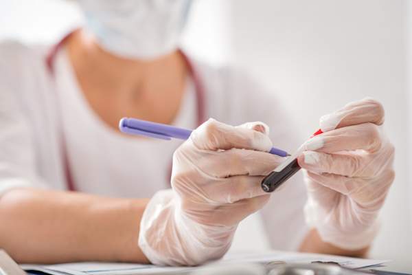 对血液样本的女研究员做笔记