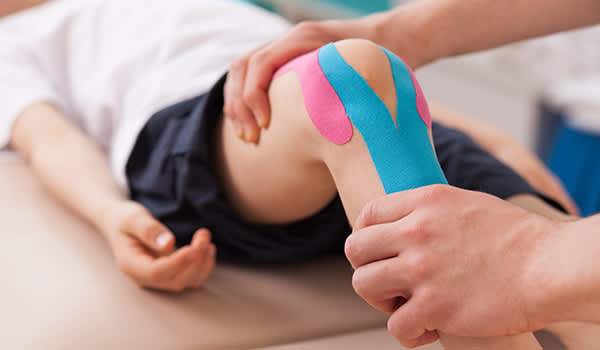 一名男子接受运动机能学运动治疗他的膝盖。
