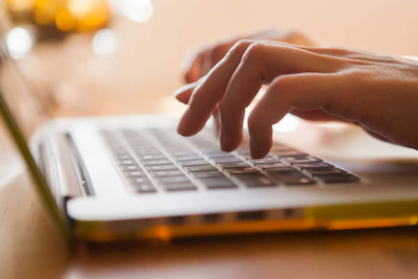 手指在笔记本电脑上打字。