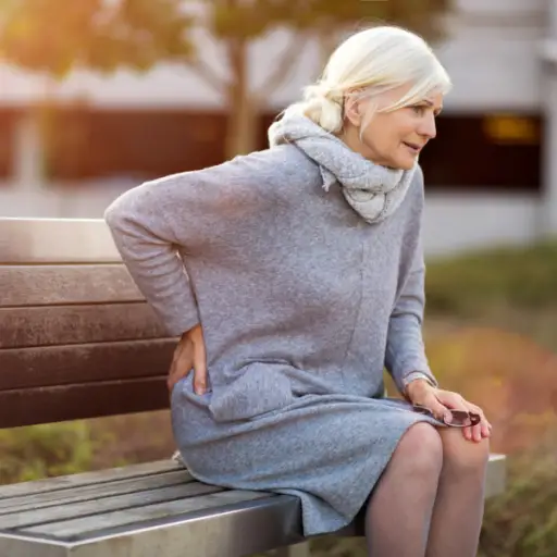 资深女性坐在长凳上时背部疼痛