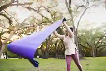 一个女人在公园里散布瑜伽垫